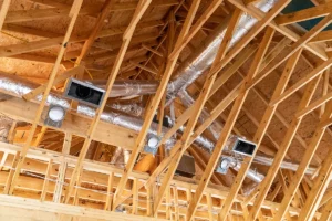 Exposed HVAC ductwork in attic during construction, showing airflow path for proper CFM distribution