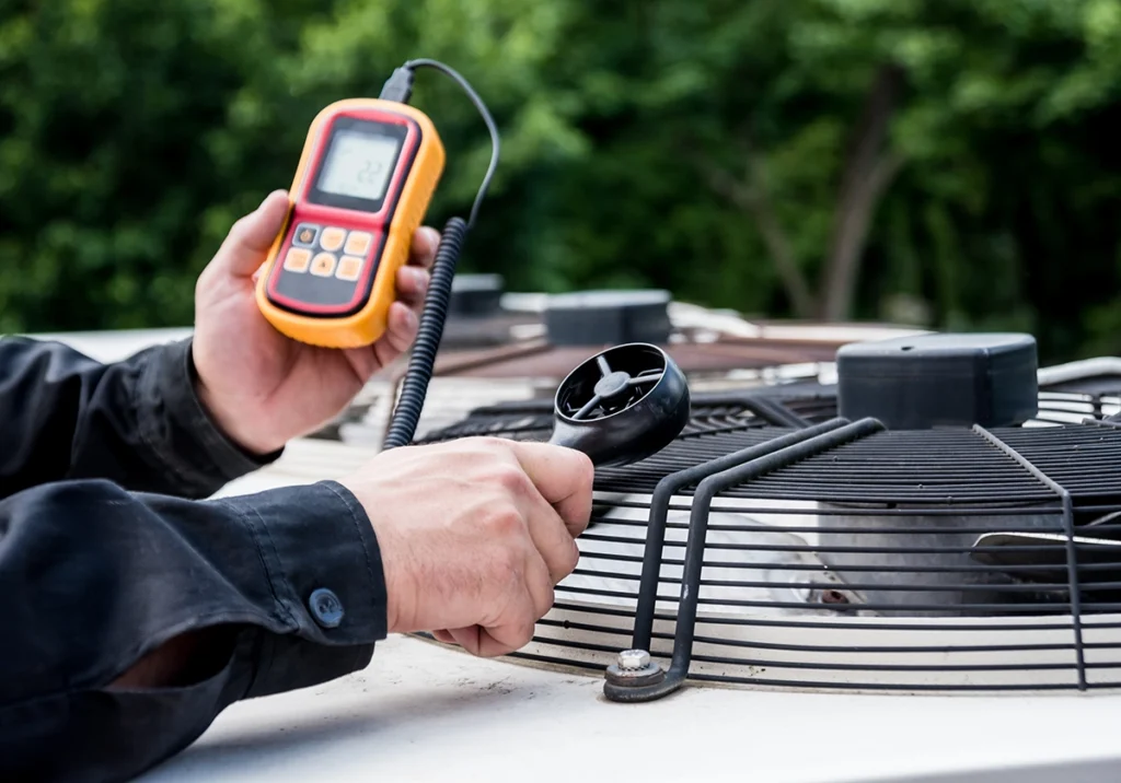 What Is CFM? HVAC technician measuring airflow with an anemometer to determine CFM
