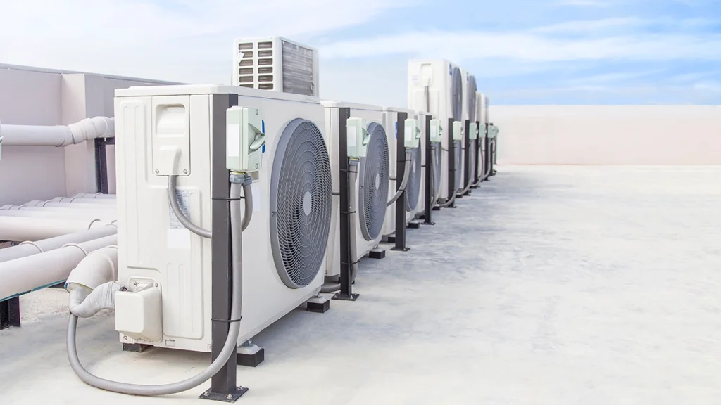 Multiple outdoor HVAC units installed in a row on a rooftop commercial building. Best for blogs about commercial HVAC, VRF or multi-zone commercial systems, rooftop HVAC equipment, commercial cooling replacement, large-building HVAC maintenance, and energy-efficient commercial HVAC.