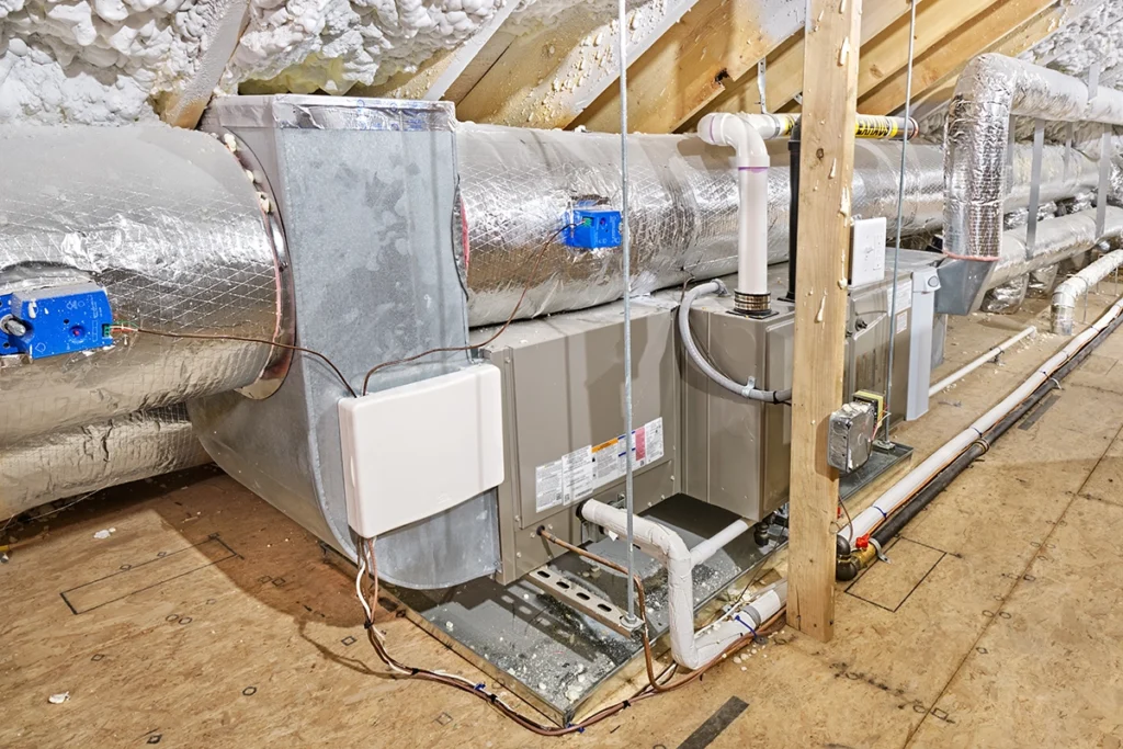 HVAC system installed in an attic with insulated ductwork, condensate lines, and air distribution components. Best for blogs about attic HVAC systems, attic ductwork, HVAC installation in attic spaces, air handler in attic, attic insulation and HVAC efficiency, and ductwork layout and performance.