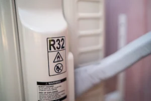 Close-up of an HVAC unit label showing R32 refrigerant warning and identification markings. Best for blogs about R32 refrigerant, new HVAC refrigerants, refrigerant changes in HVAC, environmentally friendlier refrigerants, and what refrigerant your AC uses.