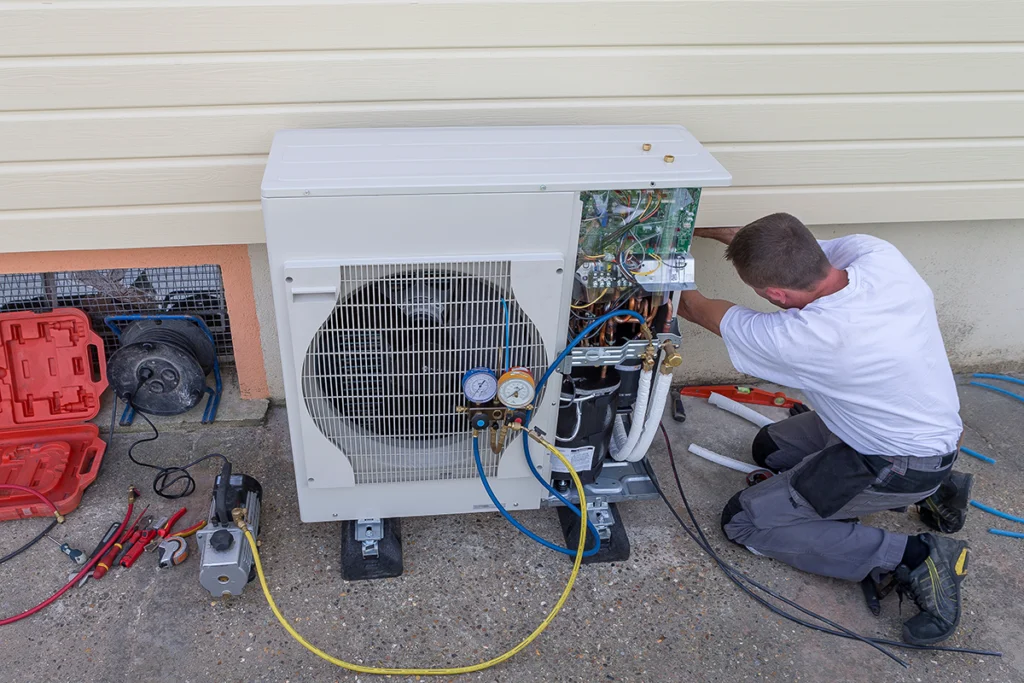 HVAC technician servicing an outdoor ductless mini split condenser unit with gauges and tools visible. Best for blogs about mini split repair, ductless system maintenance, HVAC service, and outdoor unit troubleshooting.