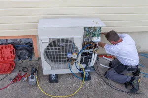 HVAC technician servicing an outdoor ductless mini split condenser unit with gauges and tools visible. Best for blogs about mini split repair, ductless system maintenance, HVAC service, and outdoor unit troubleshooting.