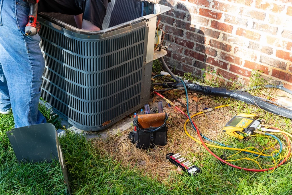 HVAC technician servicing outdoor condenser unit.