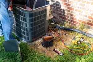 HVAC technician servicing outdoor condenser unit.