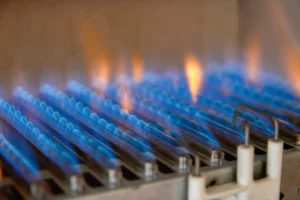 Furnace thermostat not communicating with system in Stanley NC: close-up of blue burner flames inside a gas furnace