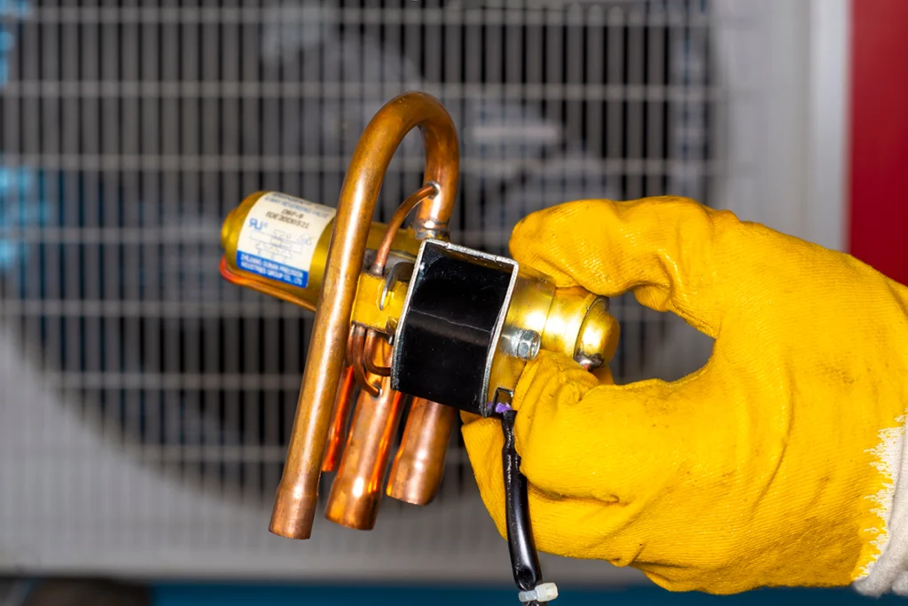 Heat pump compressor making grinding noise during startup in Indian Trail, NC: close-up of a thermal expansion valve (TXV)